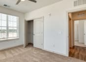 Thumbnail 6 of 40 - an empty bedroom with a large window and a door to a closet at The Walker Virginia Center, Virginia, 23059