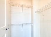 Thumbnail 46 of 47 - a walk in closet with white walls and a white closet door with a mirrored closet at The Port at East Beach Apartments and Marina, Norkfolk