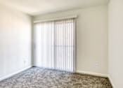 Thumbnail 15 of 56 - A room with a carpeted floor and a window with blinds.