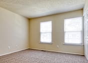 Thumbnail 11 of 26 - A room with two windows and a carpeted floor.
