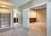 Thumbnail 12 of 33 - A large, empty room with a built-in closet and carpeted floor.