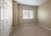 Thumbnail 14 of 33 - A room with a white door and carpeted floor.