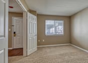 Thumbnail 13 of 33 - A room with a carpeted floor and a window with blinds.