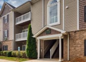 Thumbnail 16 of 21 - an apartment building with tan siding and a sidewalk