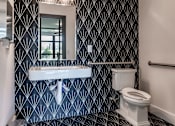 Thumbnail 22 of 39 - A bathroom with a black and white patterned wallpaper.