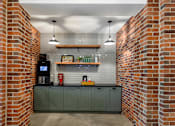 Thumbnail 20 of 39 - A brick wall with a green cabinet under it.