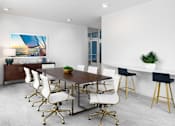 Thumbnail 14 of 42 - A modern dining room with a wooden table and white chairs.