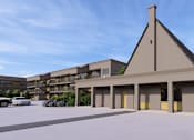 Thumbnail 19 of 20 - A modern building with a triangular roof and a parking lot in front.