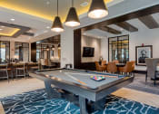 Thumbnail 21 of 38 - a billiards table in a clubhouse with tables and chairs at Aura Stonebridge, Richmond Virginia