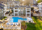 Thumbnail 12 of 20 - A large building with a pool in front of it.