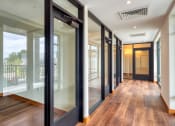 Thumbnail 13 of 81 - a hallway with glass doors and a view of a balcony at Ainsworth, Richmond, Virginia