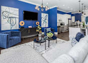 Thumbnail 16 of 20 - A modern living room with a grey sofa and a blue accent wall.