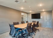 Thumbnail 33 of 42 - a conference room with a wooden table and chairs and a wall mounted tv at The Bella at Westchester, Midlothian, 23113