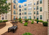 Thumbnail 15 of 60 - an apartment building with a courtyard and benches at Proximity at ODU, Norfolk, Virginia
