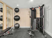 Thumbnail 17 of 34 - A home gym with a squat rack, bench, and exercise balls.