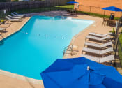 Thumbnail 15 of 22 - a swimming pool with chairs and umbrellas around it