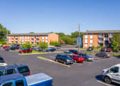 Thumbnail 22 of 22 - a parking lot with cars in front of an apartment building