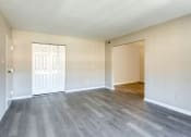 Thumbnail 45 of 52 - an empty living room with white walls and wood flooring at Bayville Apartments, Virginia Beach