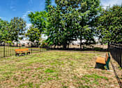 Thumbnail 17 of 21 - A park with a grassy area and two benches.