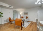 Thumbnail 8 of 22 - a living room with a couch and chairs and a dining table