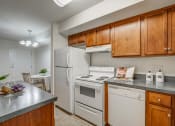 Thumbnail 2 of 22 - a kitchen with white appliances and wooden cabinets
