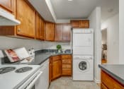 Thumbnail 4 of 22 - a kitchen with a washing machine and a dishwasher and wooden cabinets