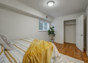 Thumbnail 12 of 22 - a bedroom with a bed and a yellow blanket