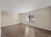 Thumbnail 11 of 21 - a bedroom with hardwood floors and a window