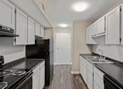 Thumbnail 8 of 21 - a kitchen with white cabinets and black countertops