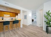 Thumbnail 24 of 31 - A kitchen with wooden cabinets and a bar area with two stools.