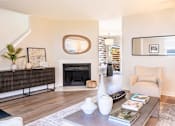 Thumbnail 3 of 31 - A living room with a fireplace, a chair, and a coffee table.