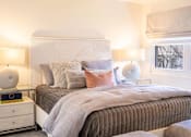 Thumbnail 17 of 31 - A bedroom with a bed, nightstands, and lamps.