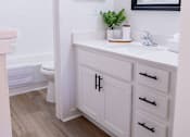 Thumbnail 20 of 31 - A bathroom with a white vanity and a mirror above it.