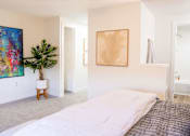 Thumbnail 19 of 31 - A bedroom with a large bed and a painting on the wall.