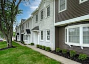 Thumbnail 23 of 31 - A row of houses with white windows and brown siding.
