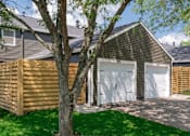 Thumbnail 14 of 31 - A house with a white garage door is surrounded by a green lawn.