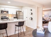 Thumbnail 7 of 31 - A modern kitchen with white cabinets and a black countertop.