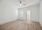 Thumbnail 27 of 56 - A room with a ceiling fan and wooden flooring.