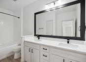 Thumbnail 29 of 56 - A bathroom with a white toilet, sink, and mirror.