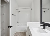 Thumbnail 30 of 56 - A white bathroom with a walk in shower and a white bathtub.