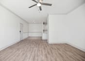 Thumbnail 21 of 56 - A room with a ceiling fan and light fixture, and a wooden floor.