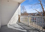 Thumbnail 31 of 56 - A white balcony with a metal railing and a white wall.