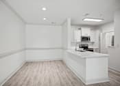 Thumbnail 22 of 56 - A kitchen with a white counter and wooden flooring.