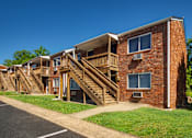 Thumbnail 28 of 31 - A red brick building with a wooden staircase leading to the second floor.