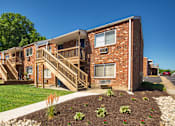 Thumbnail 26 of 31 - A red brick apartment building with a green lawn in front.