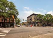Thumbnail 40 of 46 - a city street with a brown building on the corner of a street