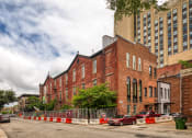 Thumbnail 41 of 46 - a large brick building with a fence in front of it