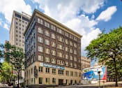 Thumbnail 2 of 16 - A street view of a city with a building that has a sign that says "Apartments for Lease".