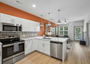 Thumbnail 23 of 59 - A modern kitchen with white cabinets and stainless steel appliances.