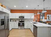 Thumbnail 25 of 59 - A modern kitchen with a refrigerator on the left and a sink on the right.
